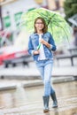 Portrait of beautiful young pre-teen girl with umbrella under spring or summer rain