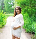 Portrait beautiful young pregnant woman in white dress outdoors Royalty Free Stock Photo