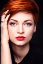 Portrait of a beautiful young red-haired woman with short hair on a dark background Royalty Free Stock Photo