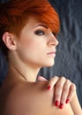 Portrait of a beautiful young red-haired woman with short hair on a dark background Royalty Free Stock Photo