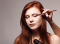 Portrait of beautiful young redheaded woman with esthetician making makeup Royalty Free Stock Photo