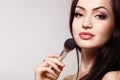 Portrait of beautiful young redheaded woman with makeup brush