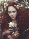 Portrait of a beautiful young sensual woman with very long red curly hair in spring flowers. Colors of spring . Royalty Free Stock Photo