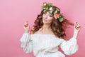 Portrait of beautiful young sexual sensual woman with perfect skin make up curly hair and flowers on head on pink background. Wrea Royalty Free Stock Photo