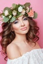 Portrait of beautiful young sexual sensual woman with perfect skin make up curly hair and flowers on head on pink background. Wrea Royalty Free Stock Photo