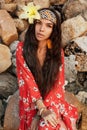 Portrait of beautiful young stylish boho woman with flower in hair outdoors at sunset Royalty Free Stock Photo