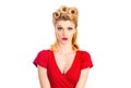 Portrait of beautiful young surprised woman, dressed in red pin-up dress. Caucasian blond model posing in retro fashion Royalty Free Stock Photo