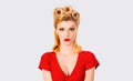 Portrait of beautiful young surprised woman, dressed in red pin-up dress. Caucasian blond model posing in retro fashion Royalty Free Stock Photo