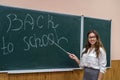 Portrait of a beautiful young teacher on a blackboard background. Back to school Royalty Free Stock Photo