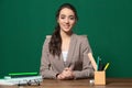 Portrait of beautiful young teacher sitting at tabl Royalty Free Stock Photo