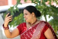 Portrait of beautiful Young traditional indian woman happy making a video call with android phone.