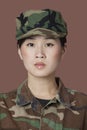 Portrait of beautiful young US Marine Corps soldier in camouflage clothing over brown background Royalty Free Stock Photo