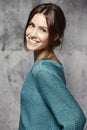 Portrait of a beautiful young woman, against cement wall