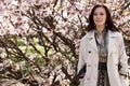 Portrait of a beautiful young woman on a background of pink cherry blossoms in spring, lifestyle concept Royalty Free Stock Photo