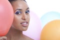 Portrait of beautiful young woman with balloons against white background