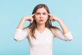 Portrait of beautiful young woman with bare shoulders touching her temples feeling stress, on blue background Royalty Free Stock Photo