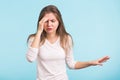 Portrait of beautiful young woman with bare shoulders touching her temples feeling stress, on blue background Royalty Free Stock Photo