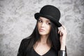 Portrait of a beautiful young woman in a black dress and bowler hat Royalty Free Stock Photo