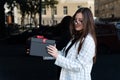 Portrait of beautiful young woman with black gift box in her hands. Happy stylish girl holds box with red bow Royalty Free Stock Photo