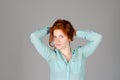 Portrait of beautiful young woman in black sports top and jeans with red curly hair, freckles and blue eyes Royalty Free Stock Photo