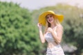 Portrait beautiful young woman blonde hair smile with yellow hat posing outdoors in green garden Royalty Free Stock Photo