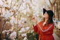 Portrait of beautiful young woman with blooming tree in spring in park. Royalty Free Stock Photo