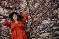 Portrait of beautiful young woman with blooming tree in spring in park. Royalty Free Stock Photo