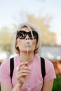 Portrait of a beautiful young woman blowing dandelion flower Royalty Free Stock Photo