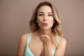 Portrait of beautiful young woman blowing kiss on color background Royalty Free Stock Photo