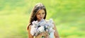 Portrait of beautiful young woman with bouquet of lilac flowers outdoors on a sunny day