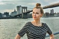 Portrait of the beautiful young woman with Brooklyn Bridge on the background.