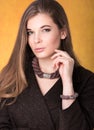 Portrait of beautiful young woman in a brown cloak with a necklace around his neck and a bracelet on her arm