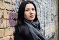 Portrait of the young woman of the brunette st the background of an old brick wall.again