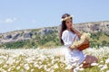 Portrait of a beautiful young woman in chamomile field. Happy girl collecting daisies. A girl resting in a field of chamomile. S Royalty Free Stock Photo