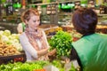 Portrait of beautiful young woman choosing green leafy vegetable Royalty Free Stock Photo