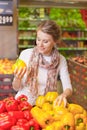 Portrait of beautiful young woman choosing vegetables in grocery Royalty Free Stock Photo