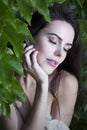 Portrait beautiful young woman with closed eyes in green leaves of wild grapes Royalty Free Stock Photo