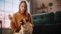 Portrait of Beautiful Young Woman Cuddles Her Adorable Little Pug at Home. Girl Plays with Her Dog Royalty Free Stock Photo