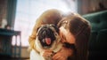 Portrait of Beautiful Young Woman Cuddles Her Adorable Little Pug at Home. Girl Plays with Her Dog Royalty Free Stock Photo