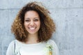 Portrait of a beautiful young woman with curly hair smiling outdoors Royalty Free Stock Photo