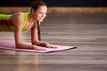 Portrait of beautiful young woman doing yoga exercise - smiling woman on the yoga mat Royalty Free Stock Photo