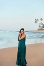 Portrait of beautiful young woman in dress on the beach. Pretty girl on tropical beach.