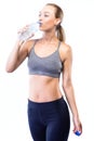 Beautiful young woman drinking water after doing exercise over white background. Royalty Free Stock Photo