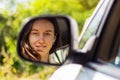 Portrait of beautiful young woman driver in car side view mirror. Royalty Free Stock Photo