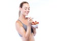 Beautiful young woman eating cereals and fruits over white background. Royalty Free Stock Photo