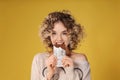 Portrait of beautiful young woman eating chocolate on color background Royalty Free Stock Photo