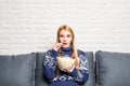 Portrait of beautiful young woman eating popcorn while watching movie in living room Royalty Free Stock Photo