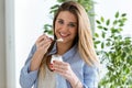 Beautiful young woman eating yogurt at home. Royalty Free Stock Photo