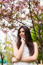 Portrait of beautiful young woman enjoying sunny day in park during cherry blossom season on a nice spring day Royalty Free Stock Photo