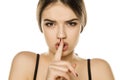 Portrait of beautiful young woman with finger on her lips Royalty Free Stock Photo